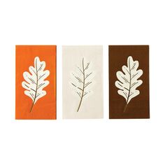 three napkins with leaves on them in different colors and sizes, one is orange, the other is brown