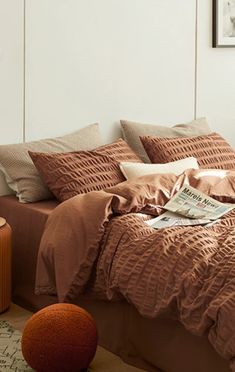 a bed with brown sheets and pillows in a bedroom