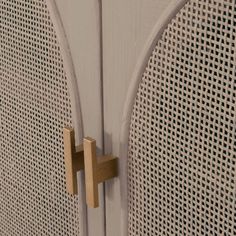 a close up of a white door with a wooden handle on it's side