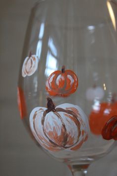 a wine glass with painted pumpkins on it