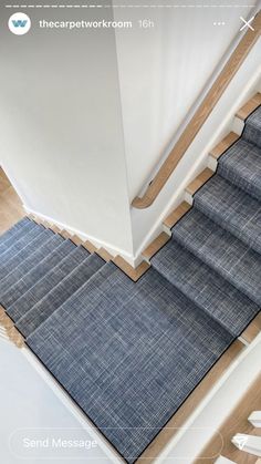 the carpeted stair treads are blue and have white trim on them, along with an area rug