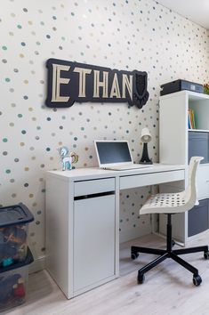 a white desk with a laptop computer on top of it next to a book shelf