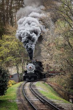 an old fashioned steam train is coming down the tracks