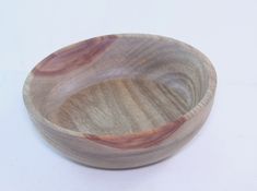 a wooden bowl sitting on top of a white table