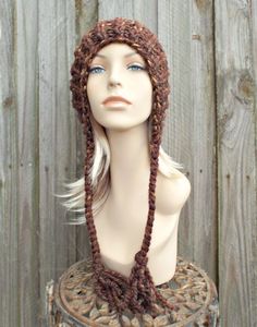 "Style: Chunky knit beanie with pom pom and braided ties, for men or women. Color: This sample hat is shown in Sequoia, a mix of browns, golds and rust. Sizes: One size fits average teen or adult head size of 20\" to 23\" (50.5 cm to 58 cm). Fiber Content: 80% acrylic, 20% Wool Characteristics: Chunky, very soft, warm and cozy. Care Instructions: Hand wash, dry flat. Every item from Pixiebell is handmade and knit or crocheted to order, unless otherwise stated in title of the item as \"ready to s Brown Knitted Beanie Cap, Knitted Brown Yarn Bonnet, Winter Brown Yarn Bonnet, Brown Knitted Beanie, Brown Yarn Bonnet Hat, Hand Knitted Brown Hats For Cold Weather, Brown Hand Knitted Hats For Cold Weather, Hand Knitted Brown Bonnet One Size, Hand Knitted Brown Yarn Hat