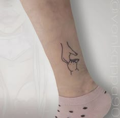 a woman's foot with a small tattoo on it