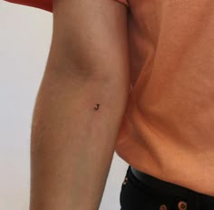 a man's arm with a tiny tattoo on the left side of his arm