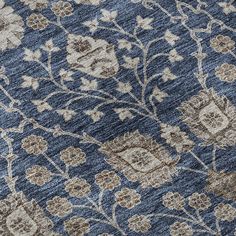 a blue and beige rug with flowers on it