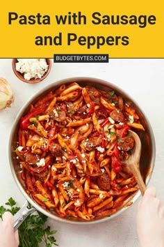 pasta with sausage and peppers in a skillet on top of a white countertop