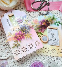 some crafting supplies are laying on a doily next to scissors and other items