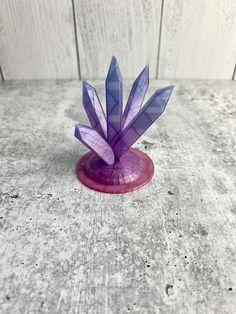 a small purple object sitting on top of a wooden table next to a white wall