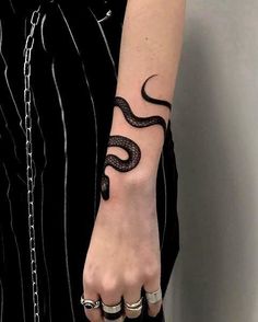 a woman's arm with a tattoo on it and a snake on the wrist