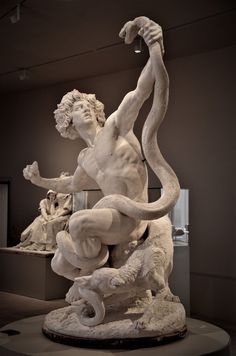 a statue of a man holding a snake