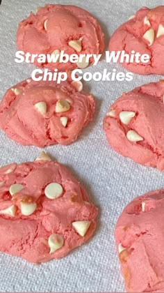 six pink cookies with white chocolate chips on a baking sheet