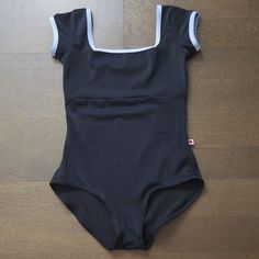 a women's swimsuit sitting on top of a wooden floor