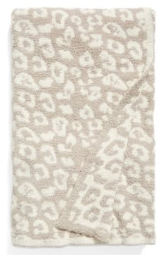 the leopard print blanket is shown in beige and white, with an animal pattern on it