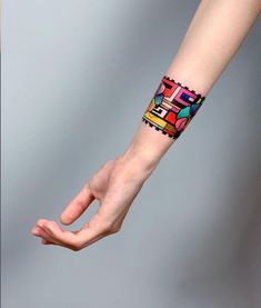 a person's arm with a colorful wristband on top of their left hand