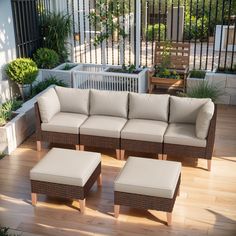 a couch and ottoman sitting on top of a wooden floor next to a planter