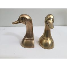 two brass ducks are sitting side by side