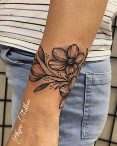 a woman's arm with a flower tattoo on it