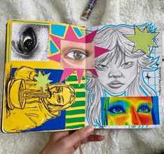 a person holding up a book with drawings on it and an eye in the middle