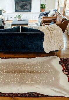 a living room filled with furniture and a rug on top of a hard wood floor