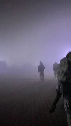 soldiers walking through fog in the dark