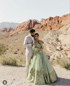 a man and woman standing in the desert