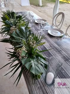 the table is set with plates, silverware and greenery for an elegant look