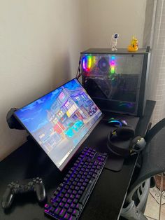 a desk with a keyboard, mouse and monitor on it next to a video game controller