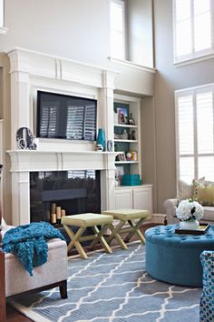 a living room filled with furniture and a flat screen tv mounted on the wall above a fireplace