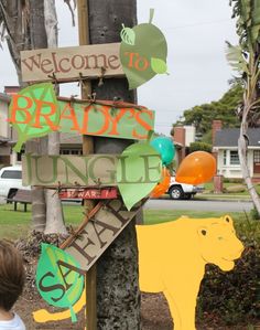 a young boy standing next to a wooden sign