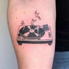 a person with a tattoo on their arm has a record player and birds flying around