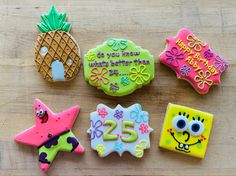 decorated cookies are arranged on a wooden surface