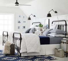 a bed room with a neatly made bed and two lamps hanging from the ceiling above it