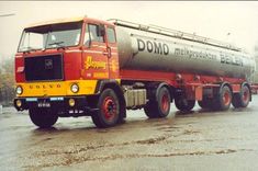 a red and yellow truck driving down a street