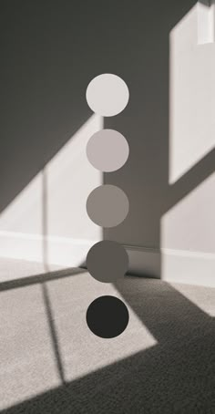 a room with some circles hanging from it's ceiling next to a wall and a window