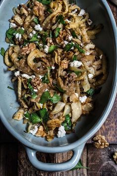 a blue bowl filled with food on top of a wooden table