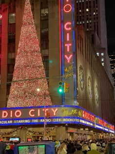 the radio city christmas tree is lit up at night