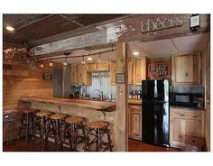 a kitchen with wooden cabinets and bar stools in front of the counter top that is made out of wood