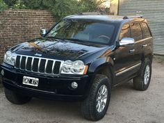 a black jeep parked in front of a brick wall