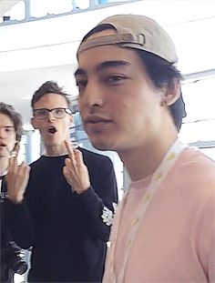 a group of young men standing next to each other in front of a mirror with their hands together