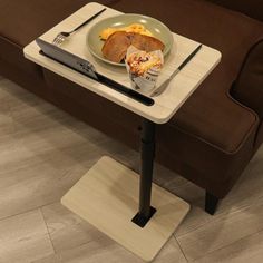 a table with a plate of food on it next to a couch and remote control