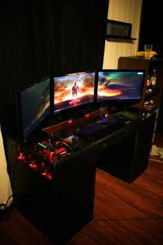 three computer monitors sitting on top of a desk