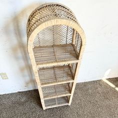 a wicker shelf sitting on the floor next to a wall