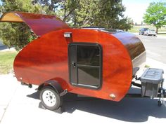 a small wooden trailer parked on the side of a road