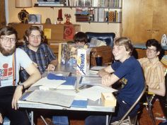 a group of young men sitting around a table