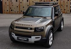 an suv parked in front of a wooden fence