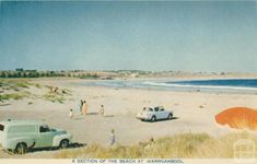 an old postcard shows people on the beach and cars parked in front of it