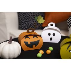 halloween decorations on a black table with white pumpkins and green candy in the background